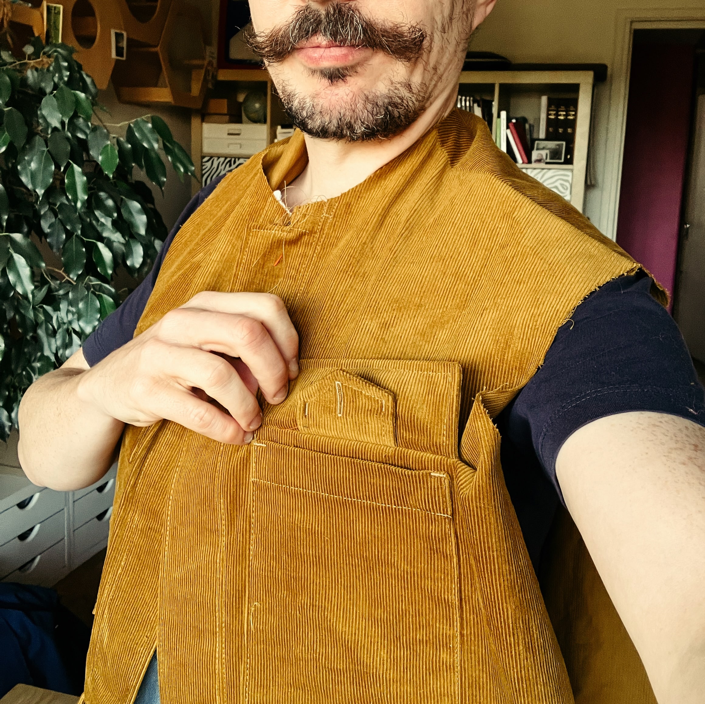 selfie d’un homme qui porte une veste pas encore finie, mais dont les poches de poitrine sont assemblées.