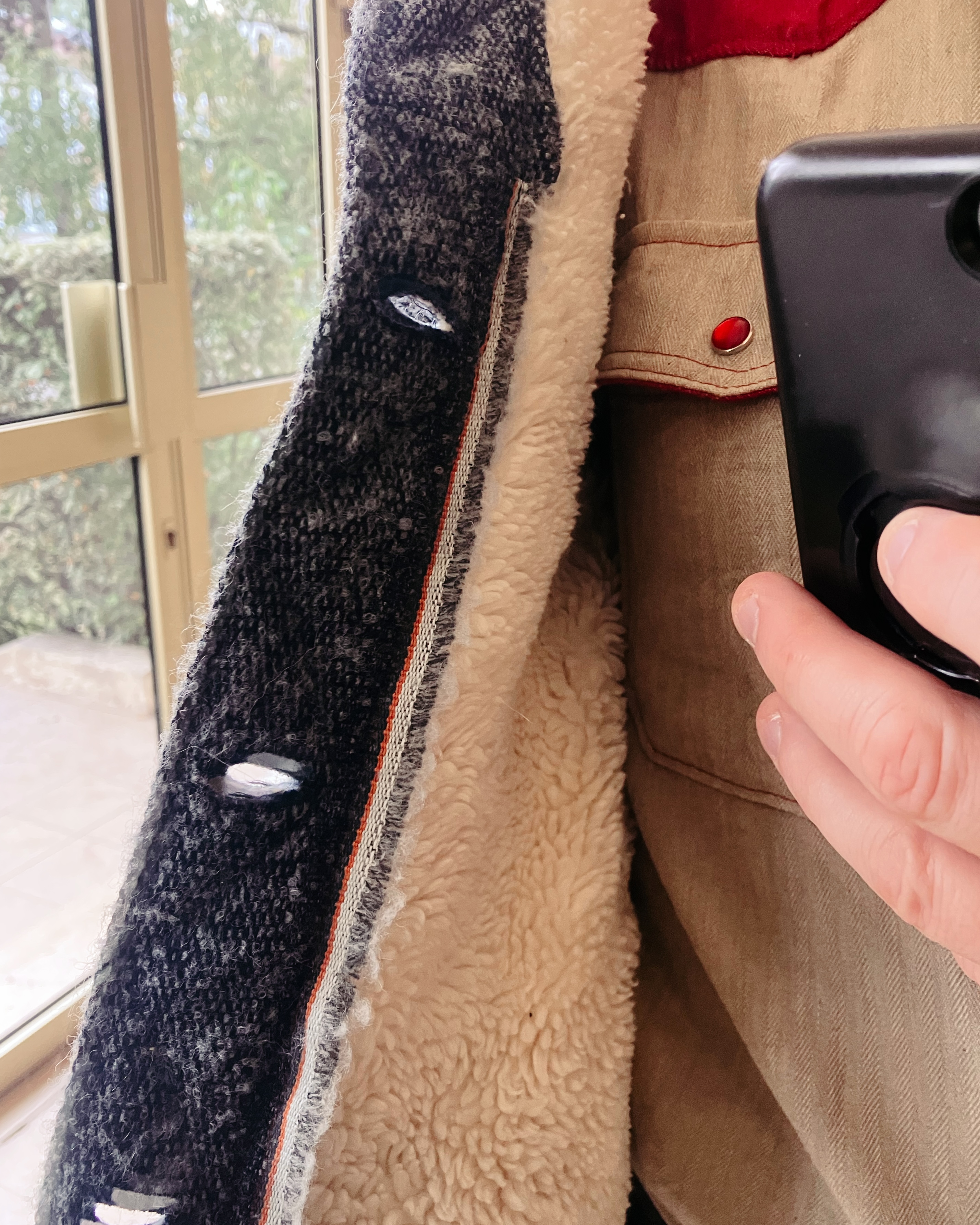 Détail du blouson qui montre l’usage du bord du tissu pour une décoration de l’intérieur de la bande de boutonnière