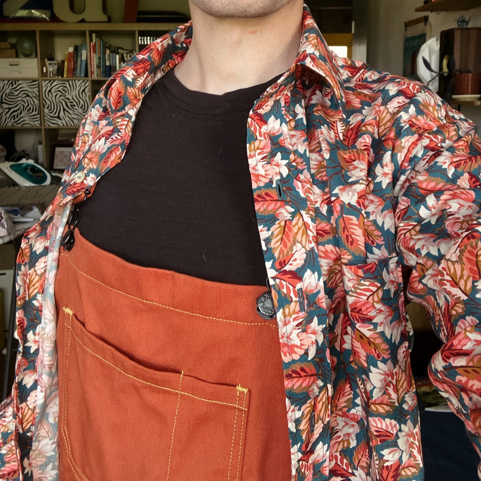 selfie d’un homme qui porte une salopette couleur brique et une belle chemise bleue pétrole à motif de feuilles d'automne oranges et roses